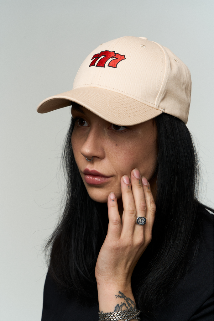 Frau trägt Beige Cap mit 777 Stick 