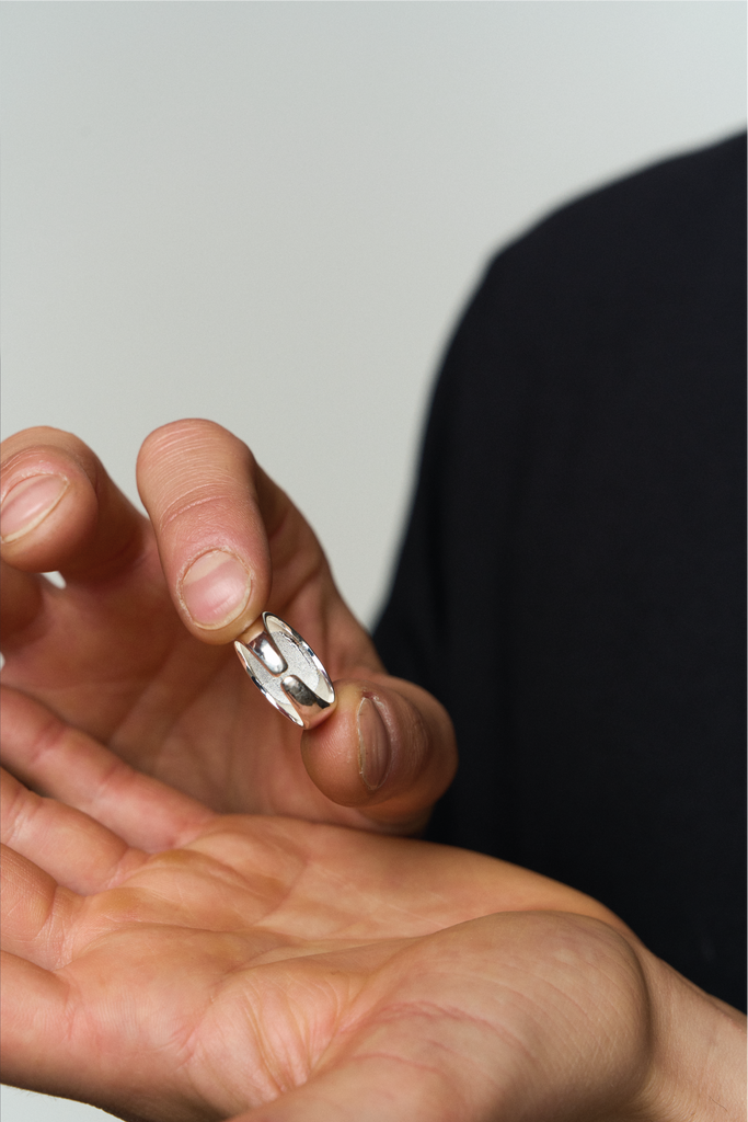 Hand mit Merkur Ring von hinten 